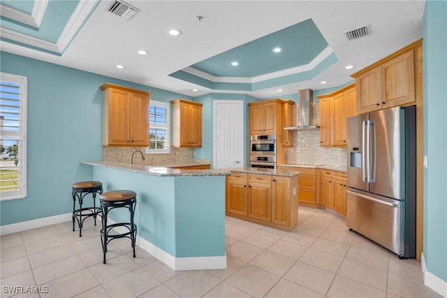 7532 Lake Valencia Ct Unit 5B, Fort Myers Beach, FL 33931 - kitchen featuring a raised ceiling, visible vents, stainless steel appliances, and wall chimney exhaust hood