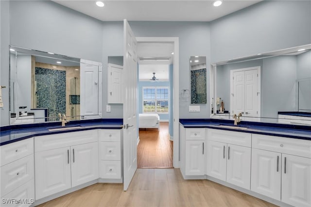 7532 Lake Valencia Ct Unit 5B, Fort Myers Beach, FL 33931 - bathroom featuring a sink, a stall shower, two vanities, and wood finished floors