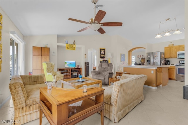 living room featuring ceiling fan, light tile patterned floors, and vaulted ceiling