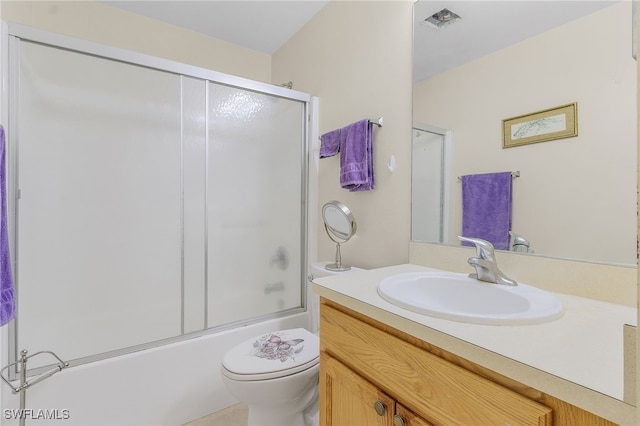 full bathroom with vanity, toilet, and bath / shower combo with glass door