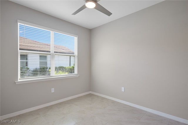 tiled spare room featuring ceiling fan