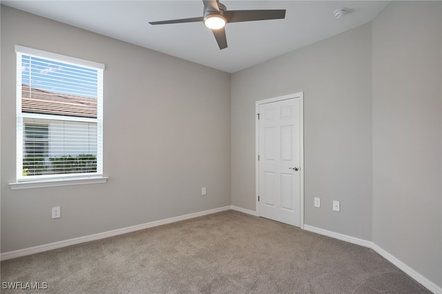 carpeted spare room with ceiling fan and a healthy amount of sunlight