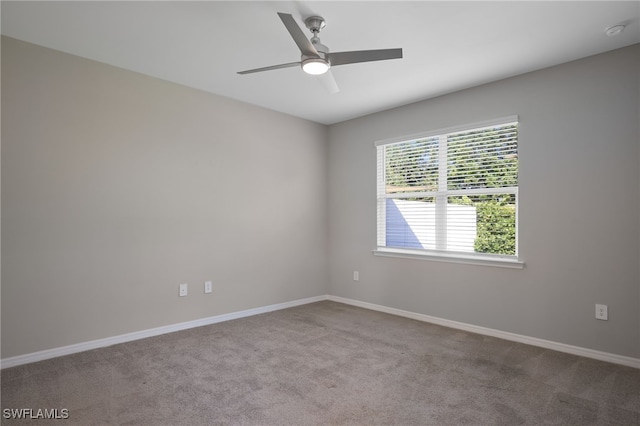 carpeted spare room featuring ceiling fan