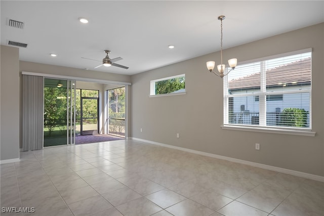 tiled empty room featuring ceiling fan with notable chandelier