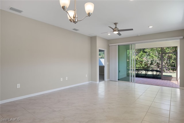 empty room featuring ceiling fan with notable chandelier and light tile patterned floors