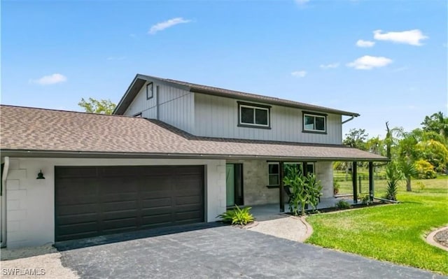 view of front of property with a porch, a garage, and a front lawn