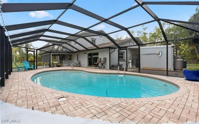 view of pool featuring glass enclosure and a patio area