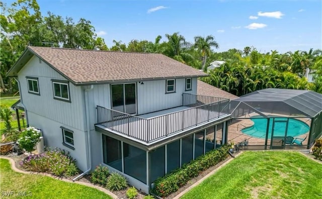 rear view of house featuring a yard and a lanai