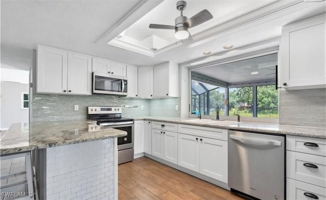 kitchen with ceiling fan, white cabinets, and stainless steel appliances