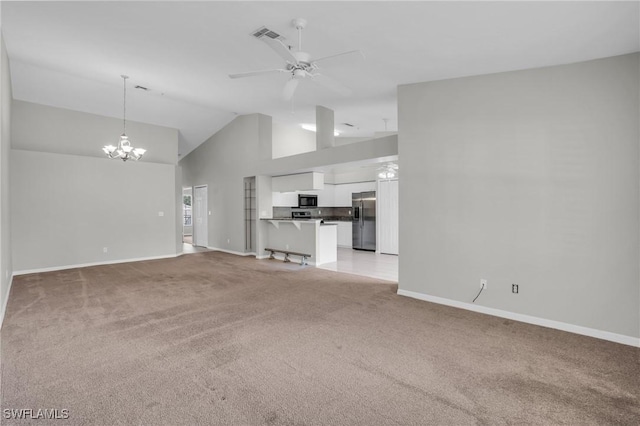 unfurnished living room featuring ceiling fan with notable chandelier, light colored carpet, and high vaulted ceiling