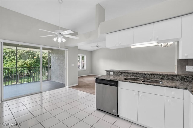 kitchen featuring white cabinetry, stainless steel dishwasher, dark stone countertops, and sink