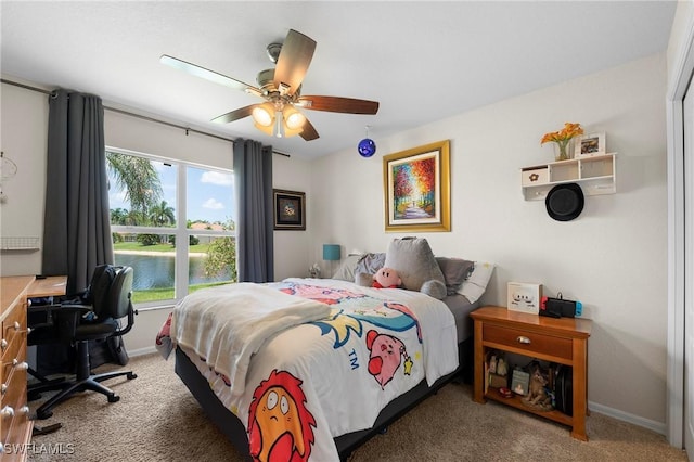 carpeted bedroom featuring ceiling fan and a water view