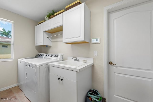 laundry room with cabinets, light tile patterned floors, sink, and washing machine and clothes dryer