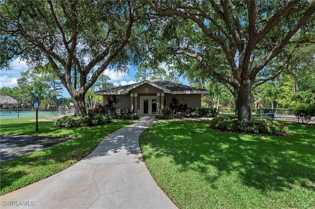 single story home with french doors and a front lawn