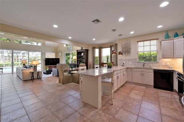 kitchen featuring dishwasher, sink, kitchen peninsula, pendant lighting, and a breakfast bar