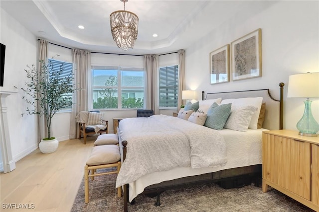 bedroom featuring hardwood / wood-style flooring, a raised ceiling, and a chandelier