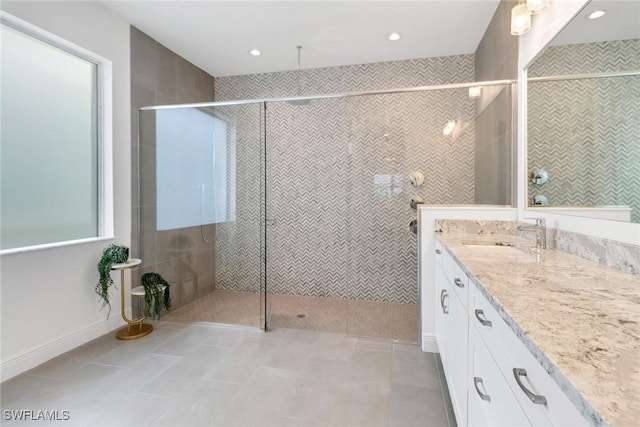 bathroom featuring tile patterned floors, vanity, and tiled shower