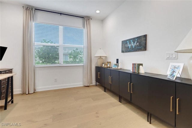 home office with light hardwood / wood-style flooring