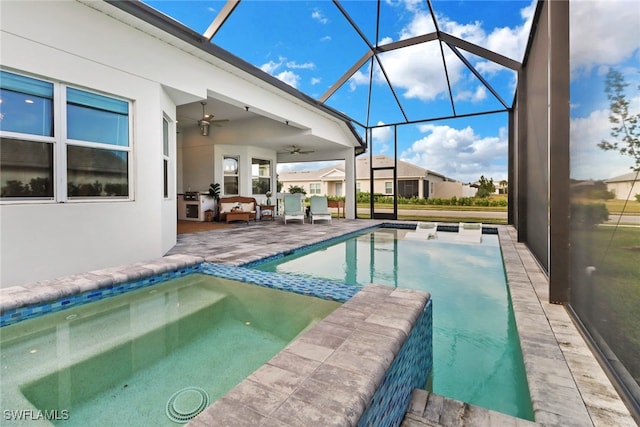 view of pool with outdoor lounge area, a patio, glass enclosure, and ceiling fan