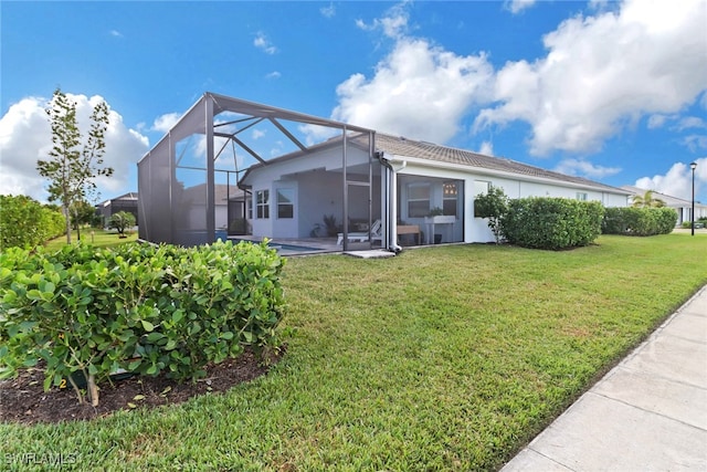 rear view of property featuring a lawn and glass enclosure