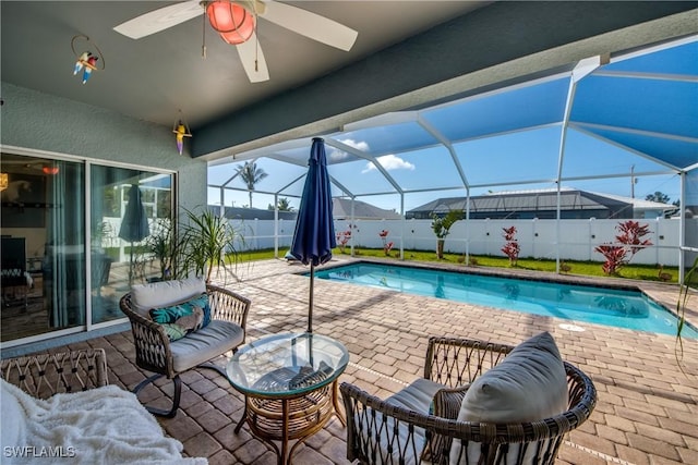 view of pool featuring a lanai, a patio area, and ceiling fan