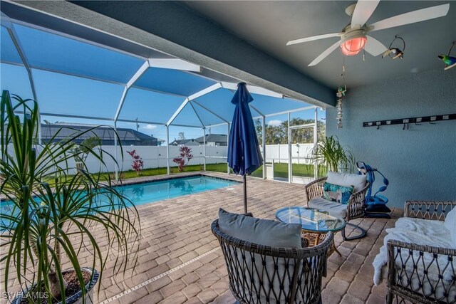 view of swimming pool featuring a patio area, ceiling fan, and a lanai