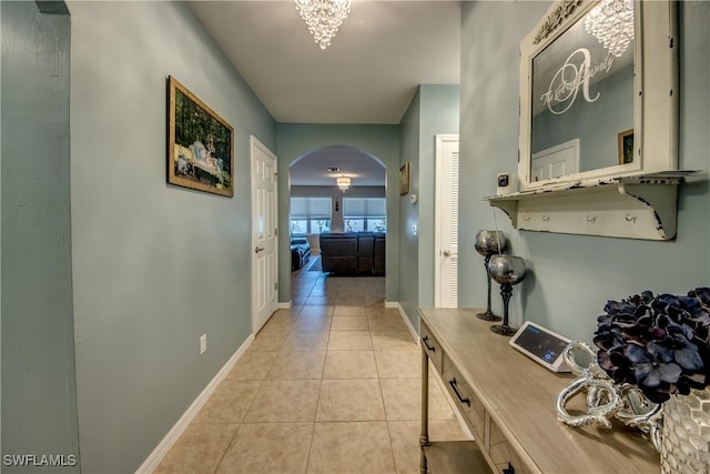 corridor with a chandelier and light tile patterned flooring