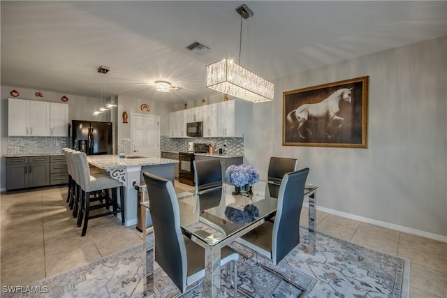 dining room featuring light tile patterned flooring, sink, and an inviting chandelier