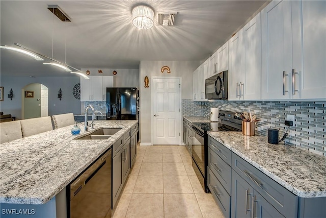 kitchen featuring white cabinetry, sink, hanging light fixtures, light tile patterned flooring, and black appliances