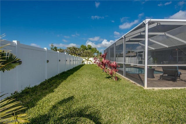 view of yard with glass enclosure, a patio area, and a fenced in pool