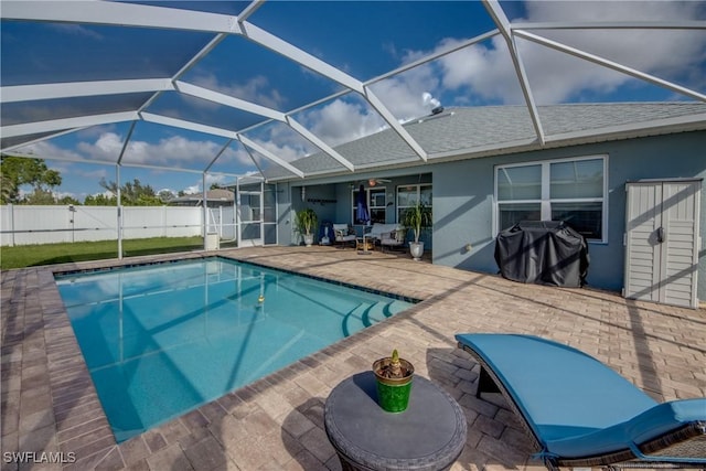 view of swimming pool featuring a patio, glass enclosure, and a grill