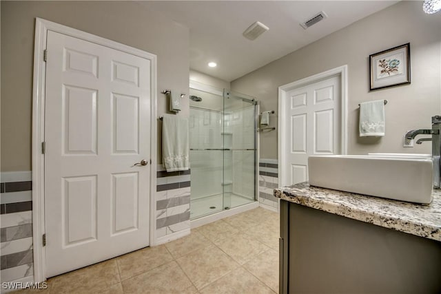 bathroom with tile patterned floors, vanity, and walk in shower