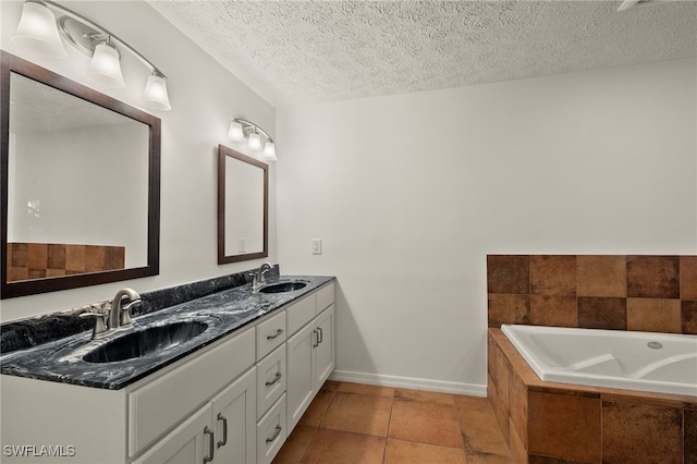 bathroom featuring vanity, tiled bath, tile patterned floors, and a textured ceiling