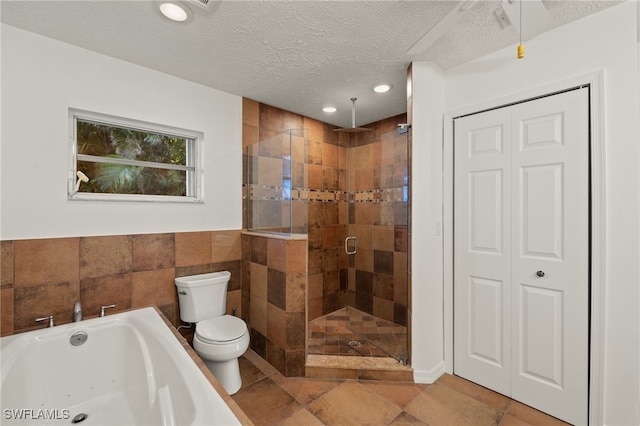 bathroom featuring a textured ceiling, plus walk in shower, and toilet