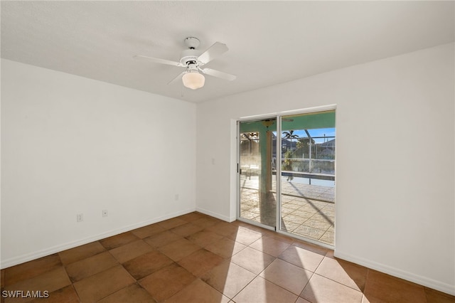 tiled spare room with ceiling fan, a sunroom, and baseboards