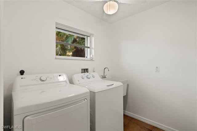 washroom featuring laundry area, dark tile patterned floors, baseboards, and separate washer and dryer