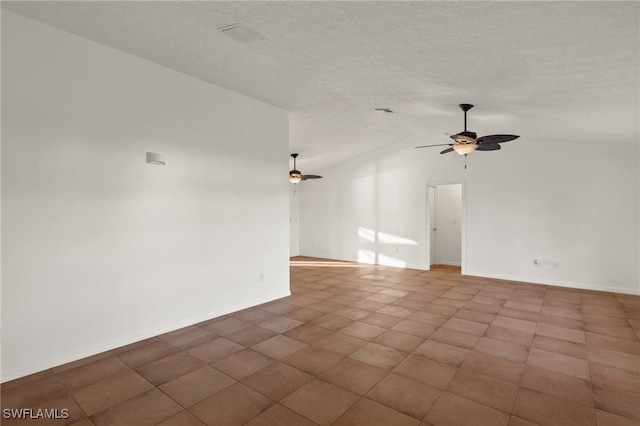 tiled empty room featuring vaulted ceiling, a textured ceiling, and ceiling fan