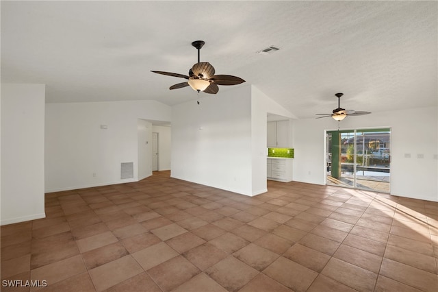 unfurnished living room with lofted ceiling, tile patterned floors, and ceiling fan