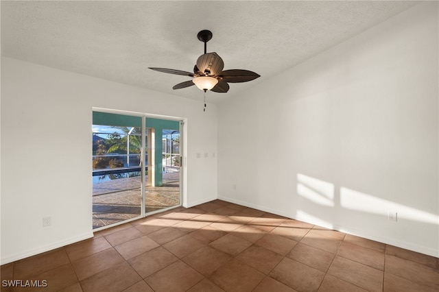 tiled empty room with a textured ceiling and ceiling fan