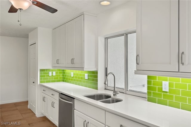 kitchen with sink, white cabinetry, tasteful backsplash, stainless steel dishwasher, and ceiling fan