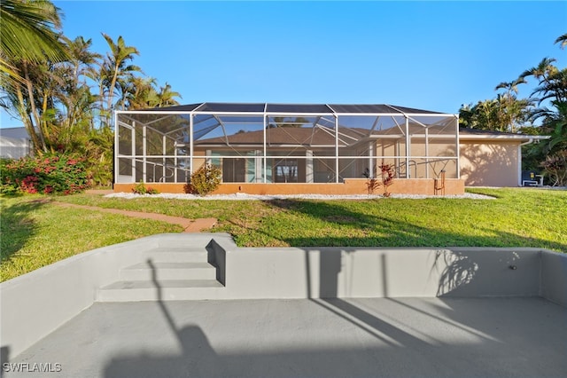 rear view of property featuring a yard and glass enclosure