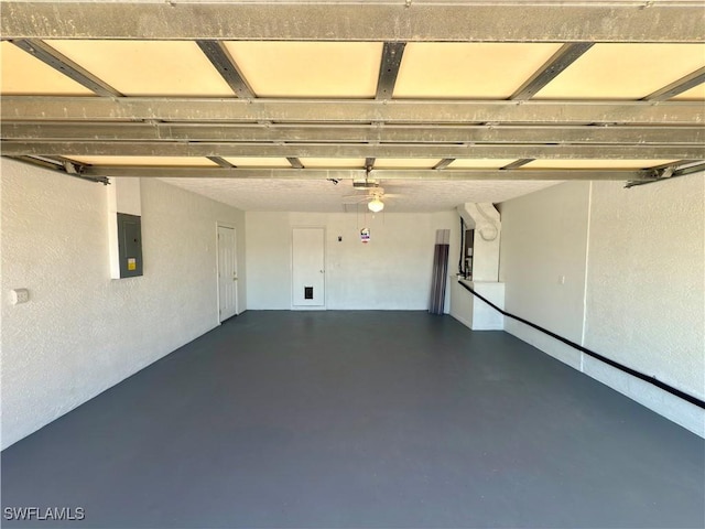 garage with electric panel and a textured wall