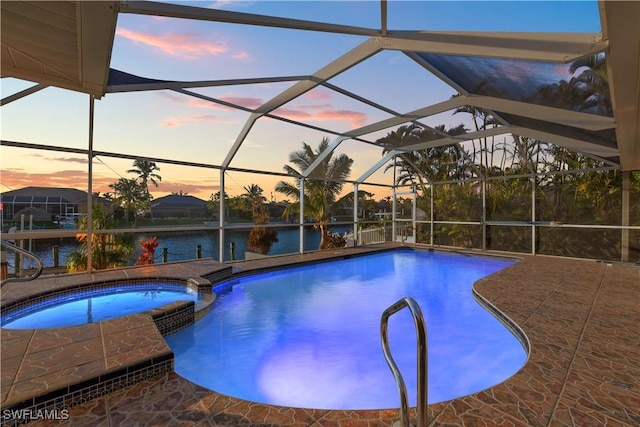 view of swimming pool featuring a patio, a lanai, and a pool with connected hot tub