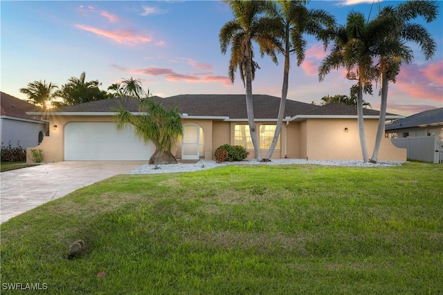 ranch-style house featuring stucco siding, fence, driveway, a garage, and a lawn