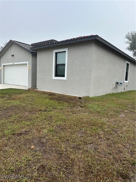 view of property exterior featuring a lawn and a garage