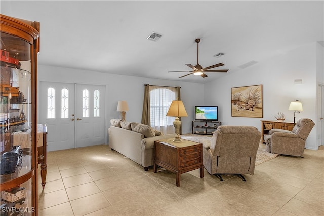 tiled living room with ceiling fan, french doors, and vaulted ceiling