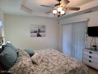 bedroom with a raised ceiling and ceiling fan