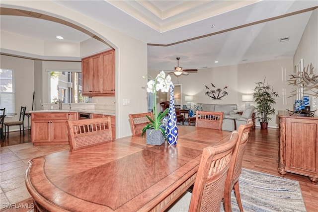 dining space with ceiling fan, sink, and light hardwood / wood-style flooring