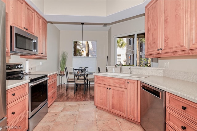 kitchen featuring decorative light fixtures, sink, and stainless steel appliances