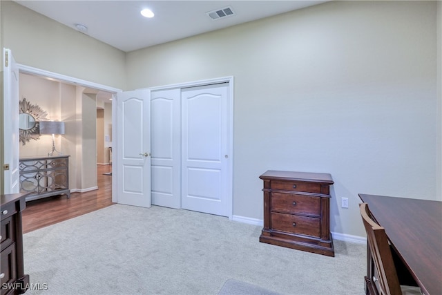 bedroom featuring light carpet and a closet